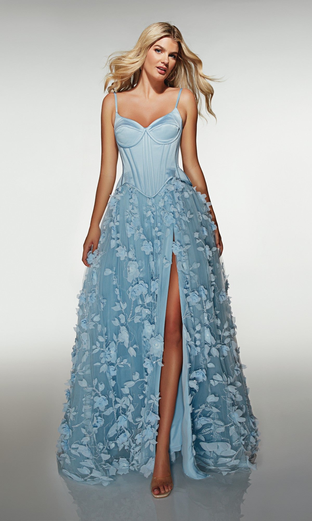 A woman wears the Alyce 62072 long formal dress in powder blue, featuring a corset bodice, 3D floral-lace appliqués on the skirt, and a high front slit.